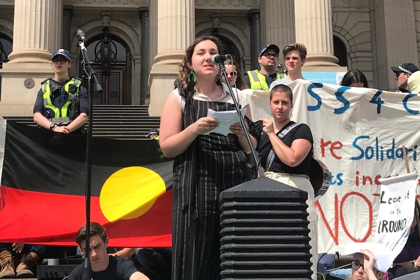 Maggie Taylor speaks into a microphone outside the Victorian Parliament.