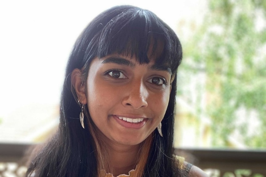 A young woman smiles at the camera