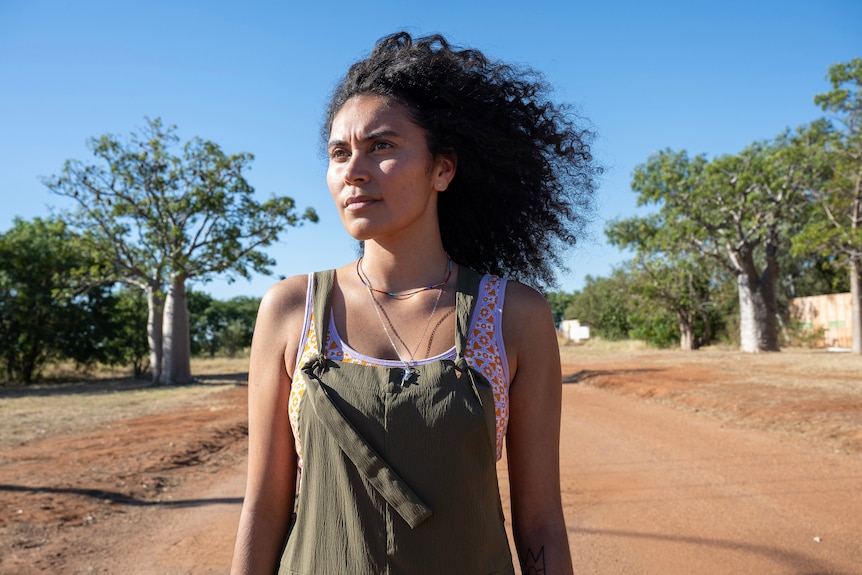 A young woman stands outside in a rural Australian town