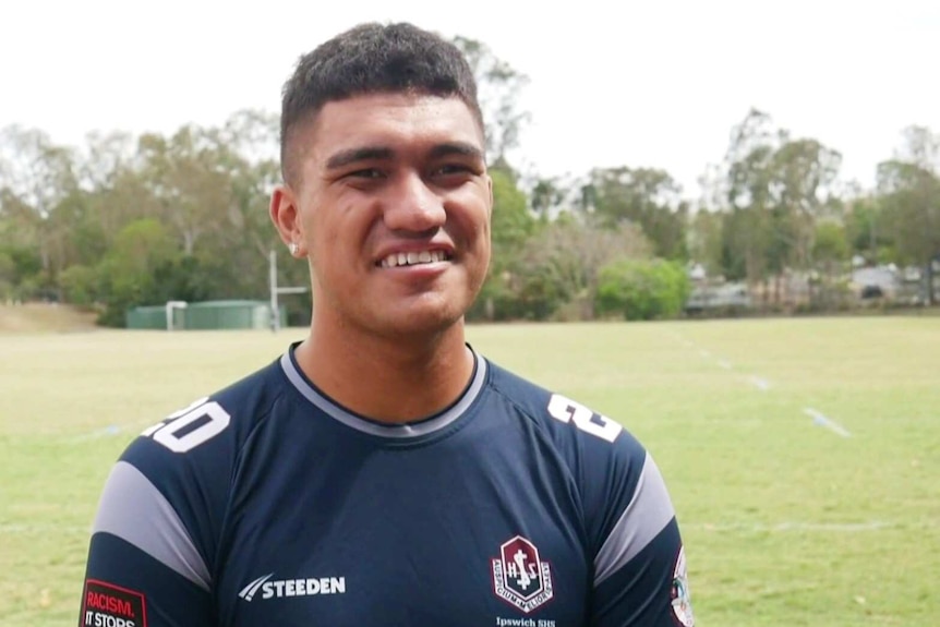 A man in a rugby jersey on a football field.