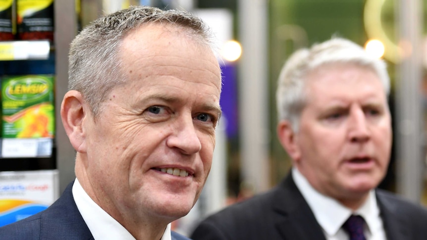Bill Shorten dons a posed smile and looks sly while in a pharmacy in sydney