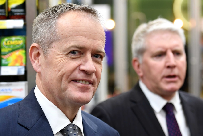 Bill Shorten dons a posed smile and looks sly while in a pharmacy in sydney
