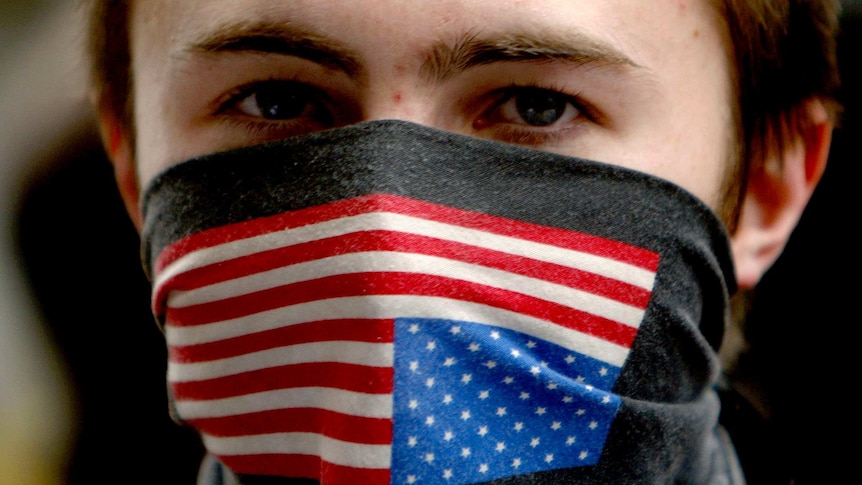 A young man with an American flag bandana across his mouth