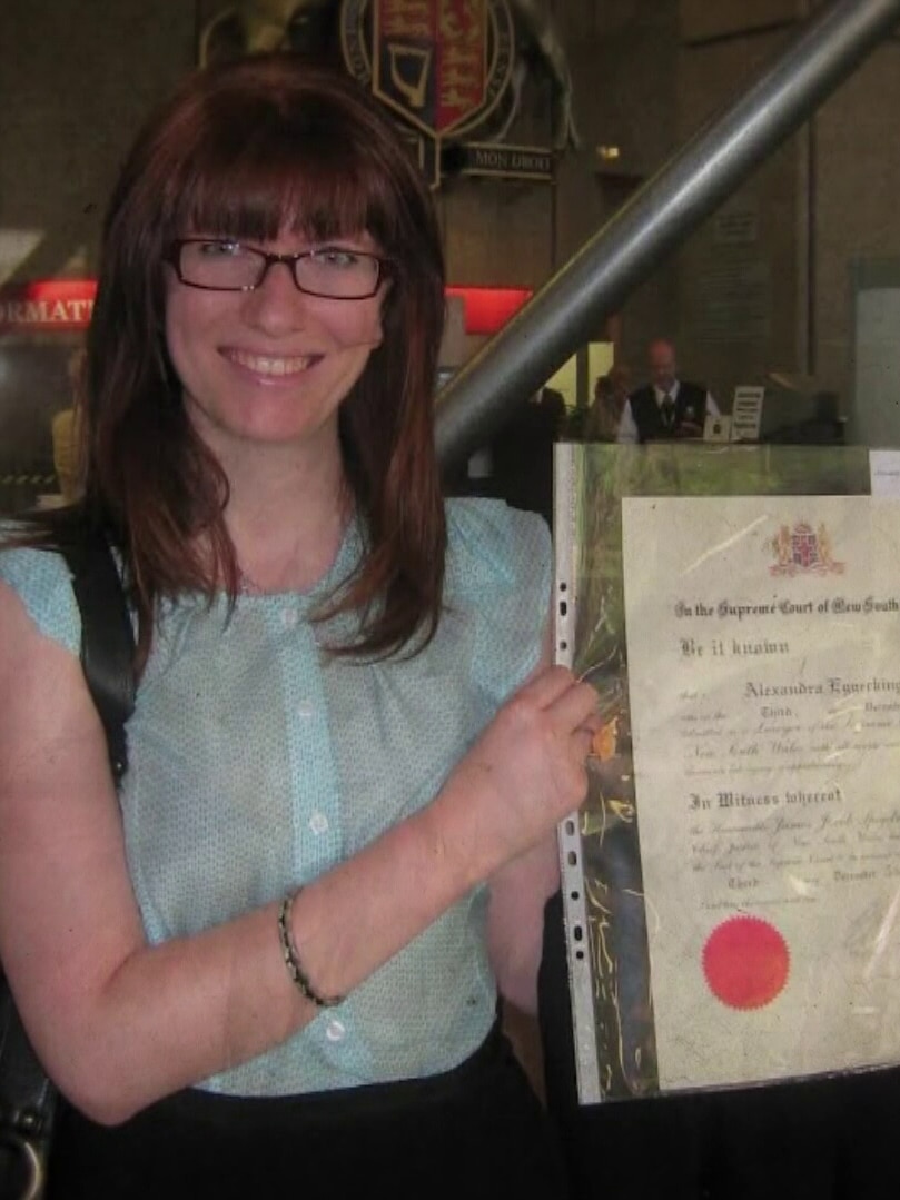 Woman holding up her law degree.