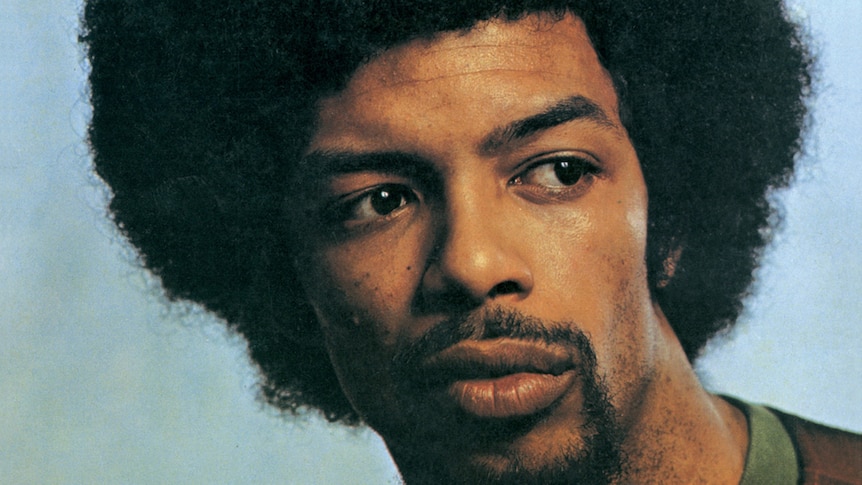 Headshot of a man with an afro hairstyle looking past the camera