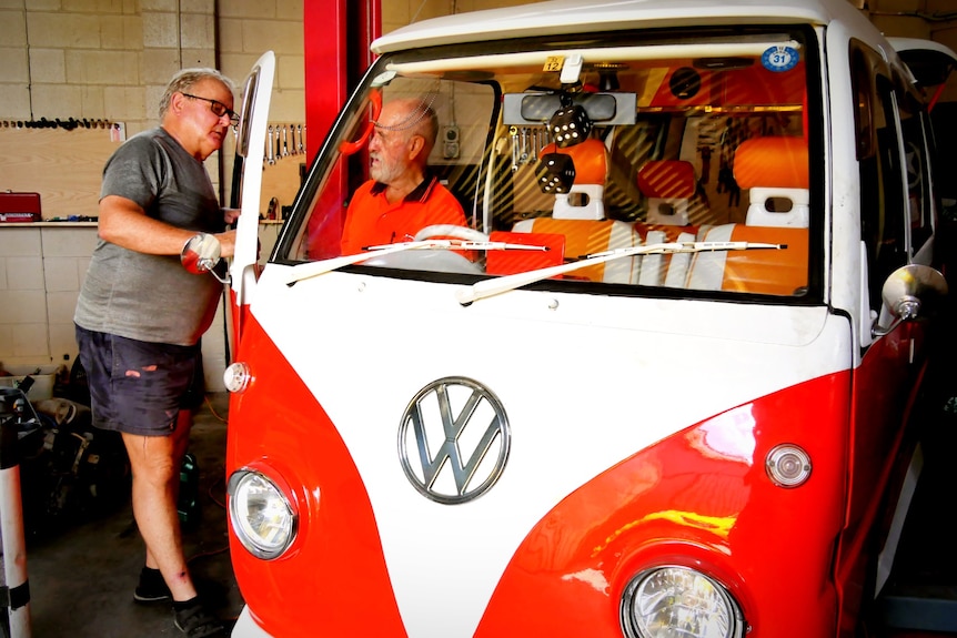 A bright-coloured VW Kombi that has been immaculately restored.