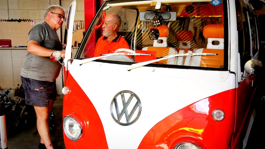 A bright-coloured VW Kombi that has been immaculately restored.