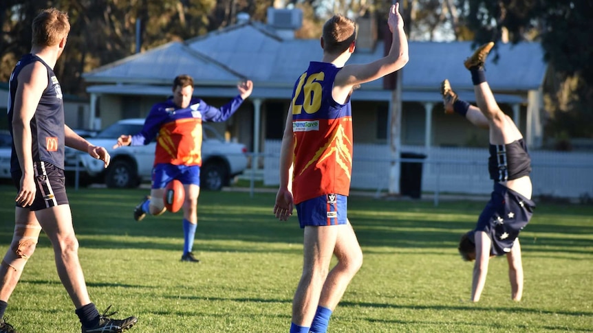 Football player does a handstand.