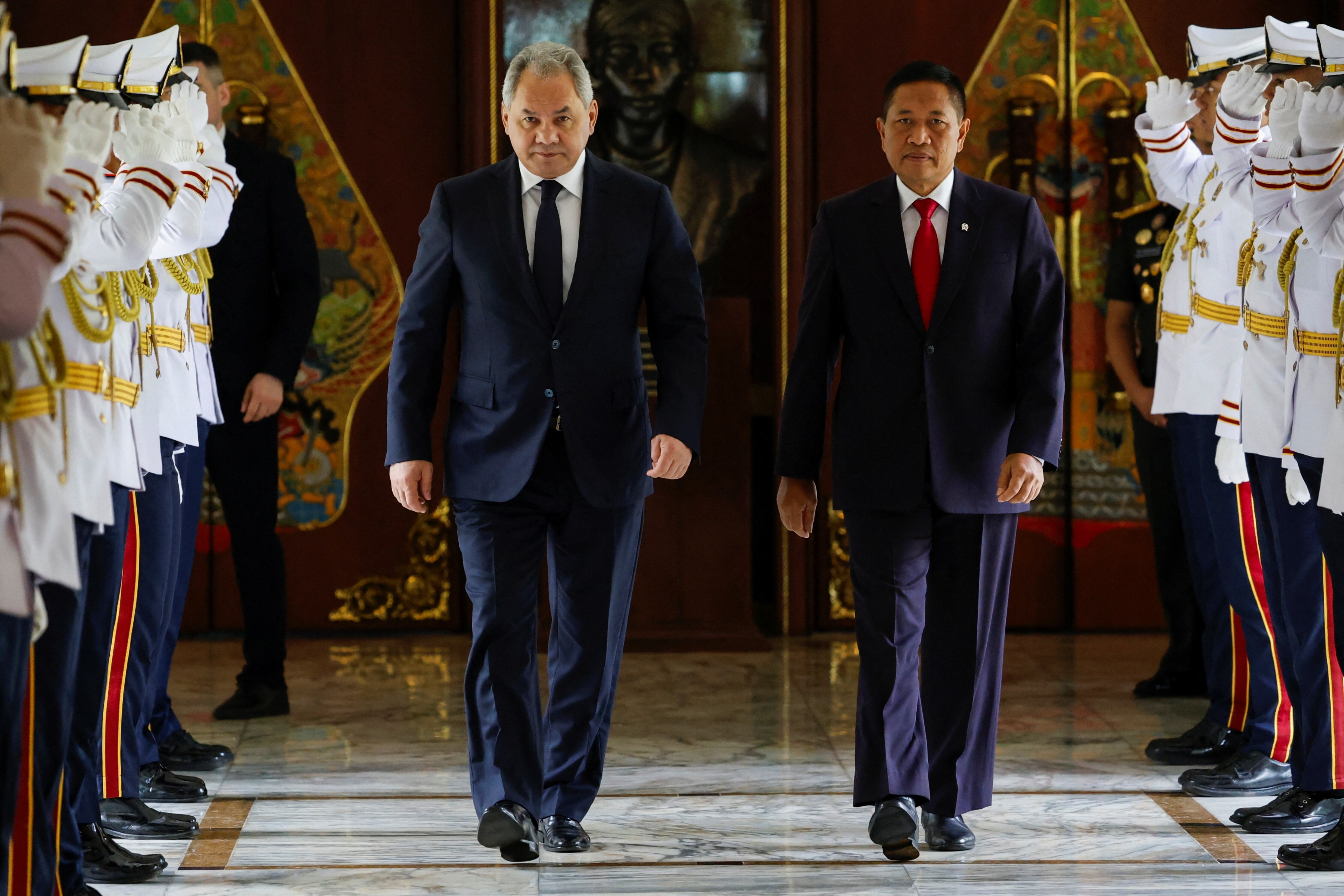 Indonesian and Russian officials walk side by side towards the camera in Jakarta.