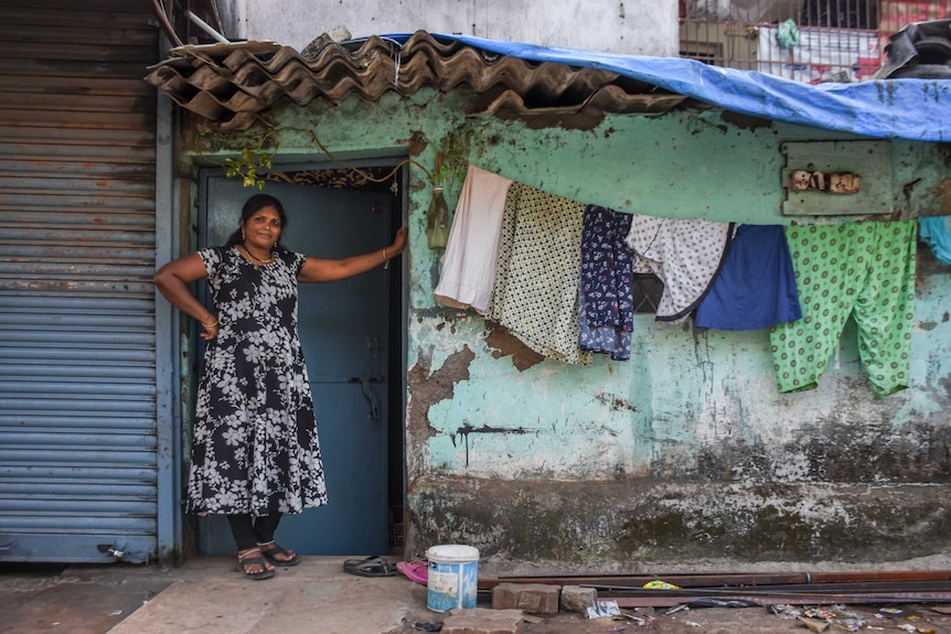 A woman standing outside her house with washing on the line