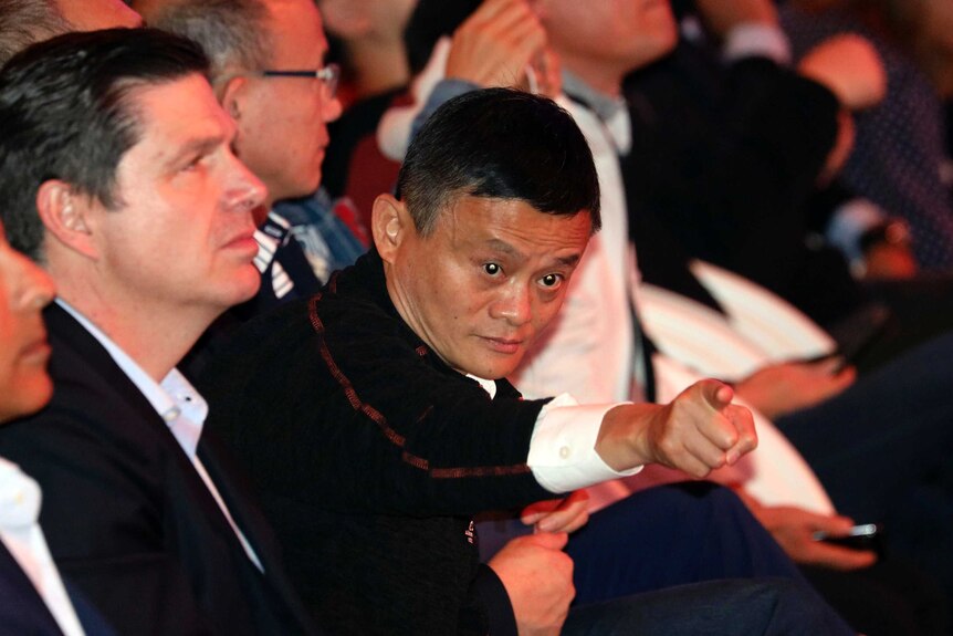 Jack Ma is seen leaning forward in his seat and pointing