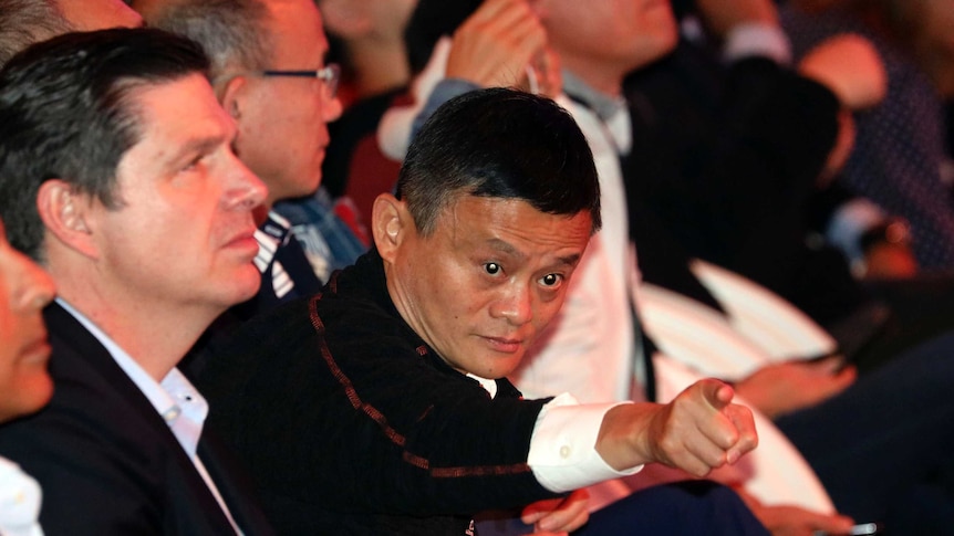 Jack Ma is seen leaning forward in his seat and pointing