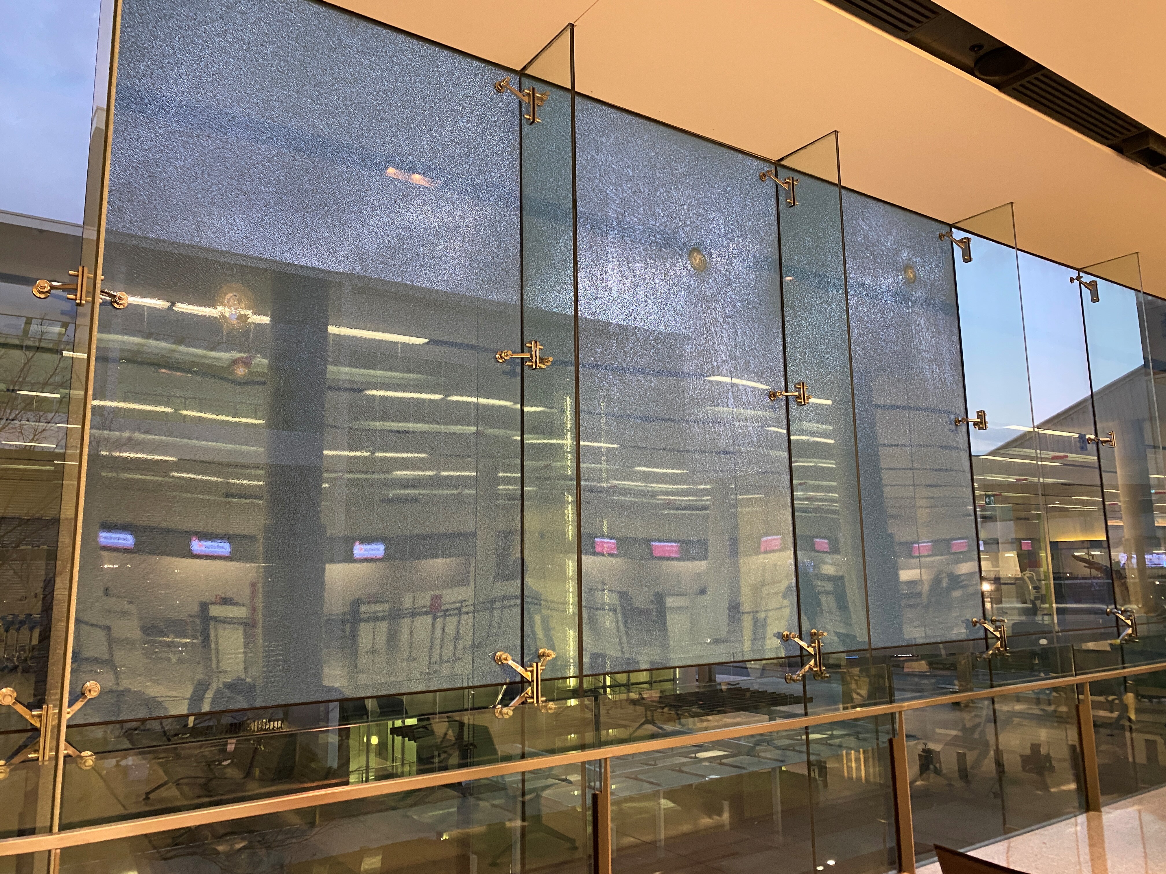 Three bullet holes in large glass windows.