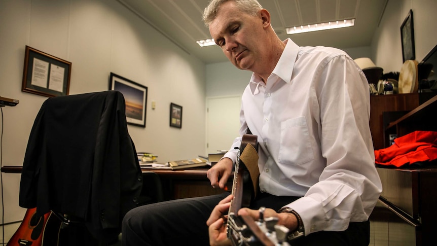 Tony Burke plays the guitar in his office at Parliament House.