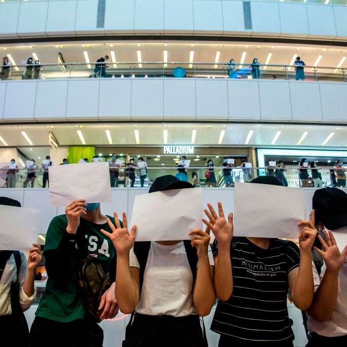 People holding up blank placards in Hong Kong protesting against new security laws