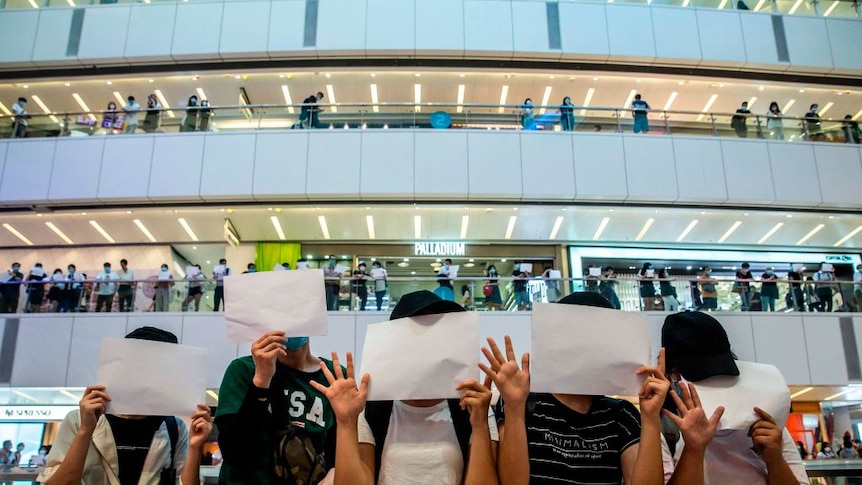 People holding up blank placards in Hong Kong protesting against new security laws
