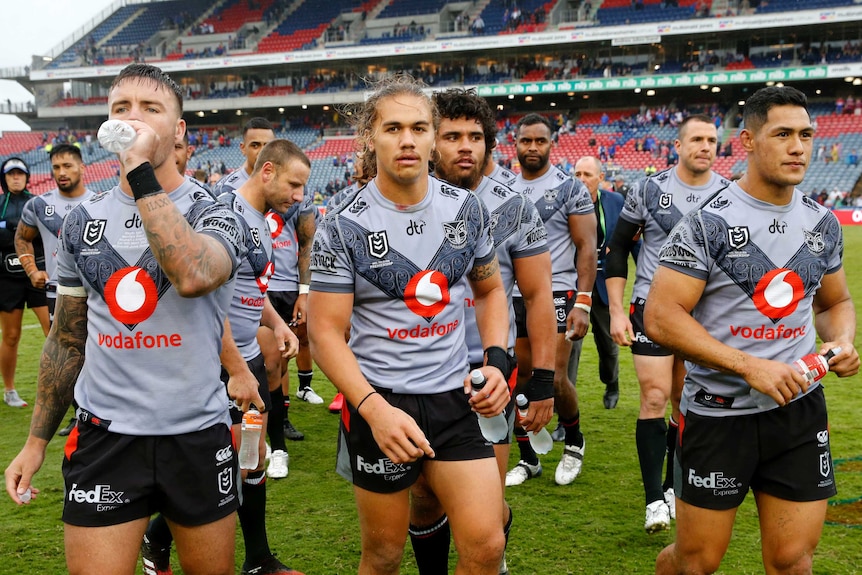 Male Warriors players walk off the field after losing a match to the Knights in Newcastle.