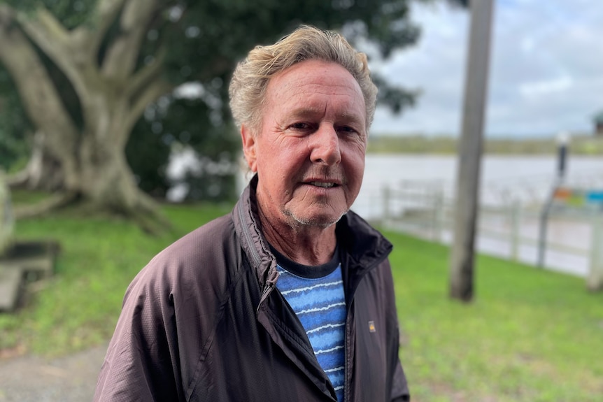 Head shot of man wearing blue striped shirt and black rain jacket