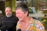 Jo Wynne cries as she is interviewed by reporters outside court, as a man looks on in the background.