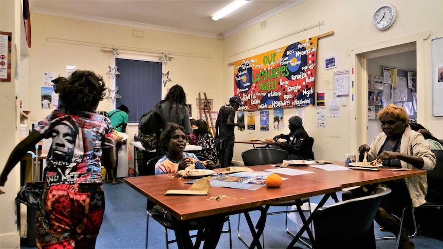 Native people in a drop-in centre, having something to eat.