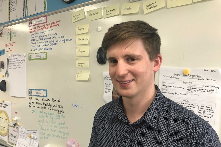 A headshot of teacher Tom Davis in front of a whiteboard in his classroom at Montmorency South Public school in Melbourne.