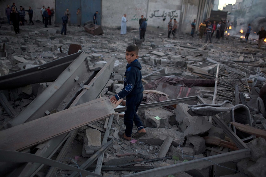 A child stands among the rubble after exchange of fire in Gaza.