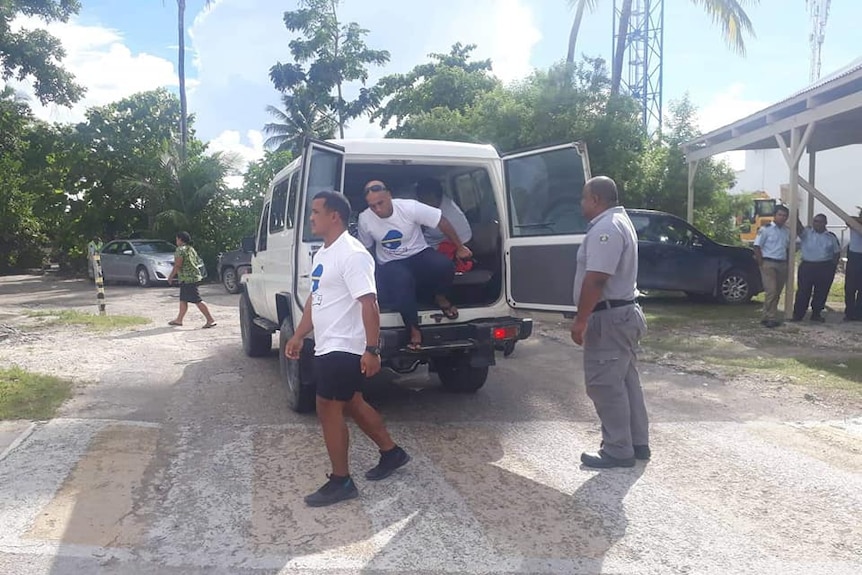 Some members of Nauru 19 getting out of a van.