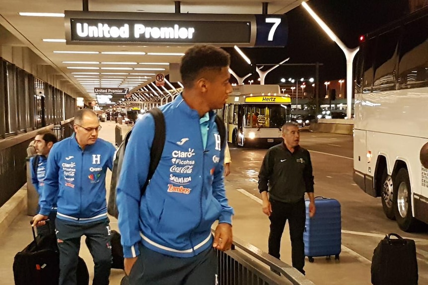 Honduran players and staff at airport.