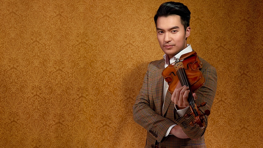 Ray Chen with his violin, wearing a suit
