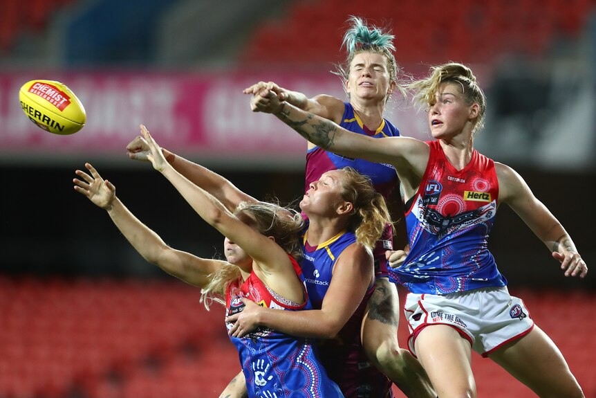 Tayla Harris of the Melbourne Demons spoils over a pack of players