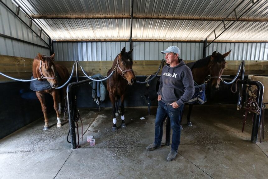 El entrenador Darren Weir está con tres de sus caballos