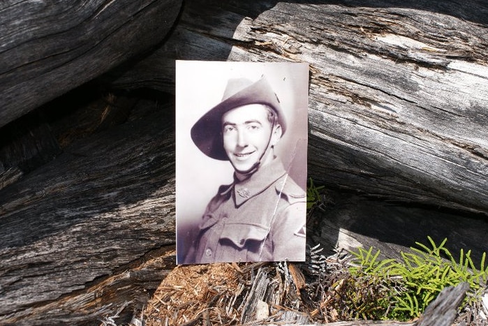 Ray 'Boy' Miles photo, set against logs in Tasmania high country.