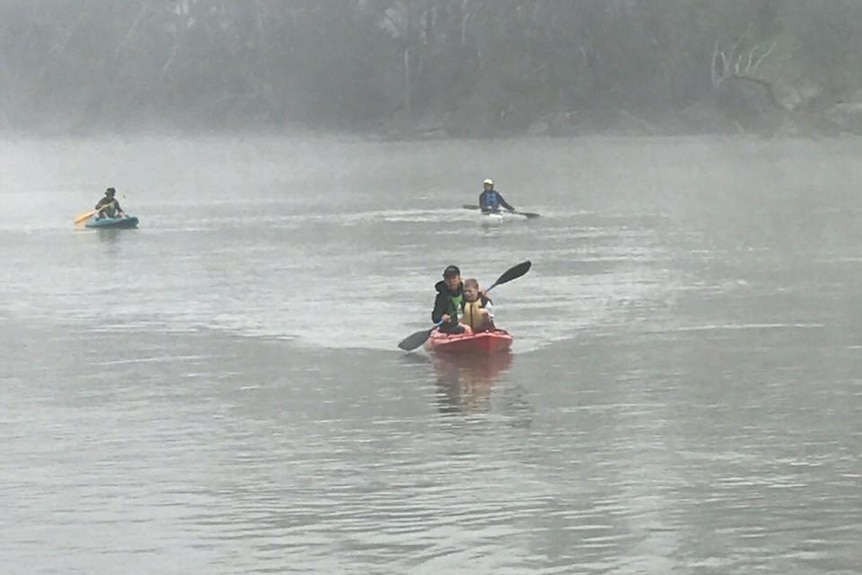 A small group paddles on a lake