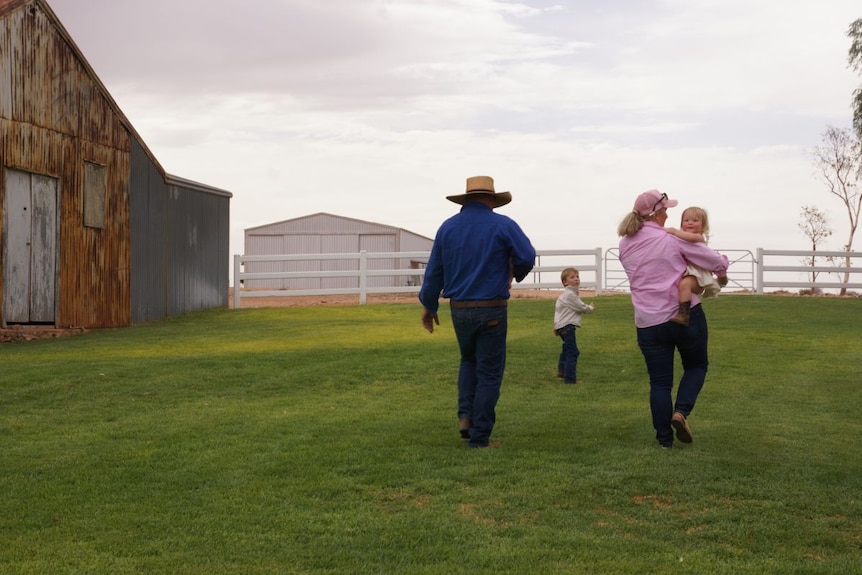The Mackay family walk through a paddock.