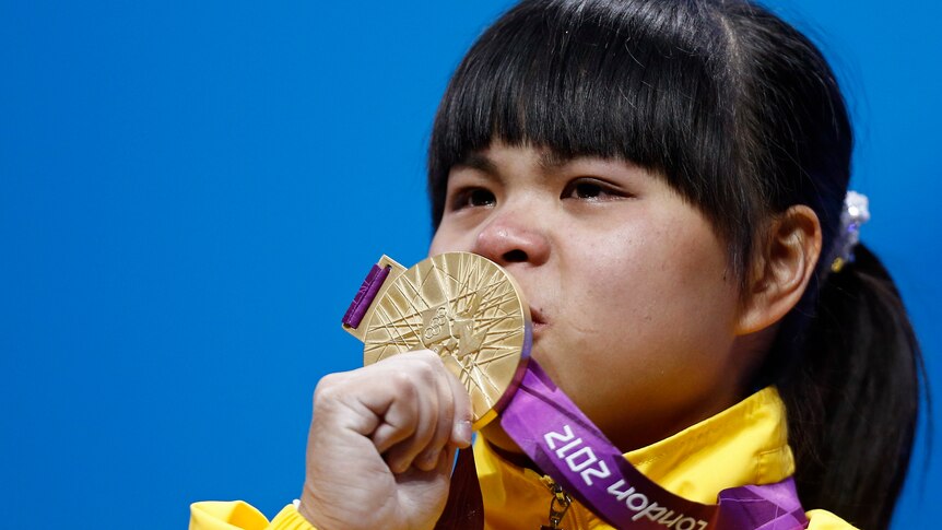 Zulfiya Chinshanlo kisses her gold medal after winning the women's 53Kg weightlifting.