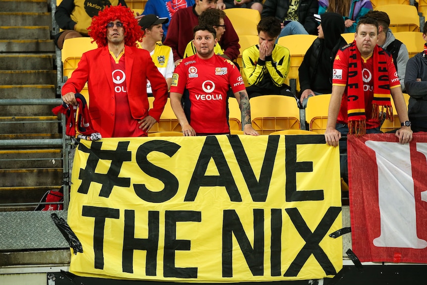 A banner in yellow and black saying 'Save The Nix' is held up during a soccer game in Australia