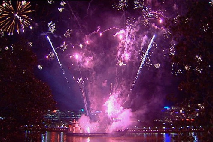 Pink and blue fireworks explode from a river barge in Brisbane.