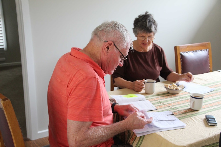 Jan and Geoff Mckergow sit at the table reading documents.