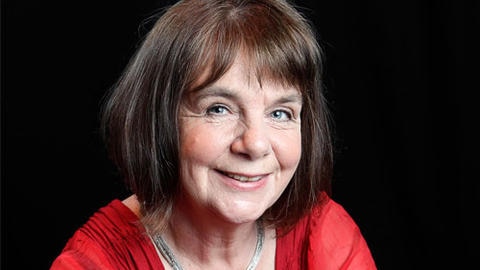 Julia Donaldson wears a red top and is smiling directly at the camera