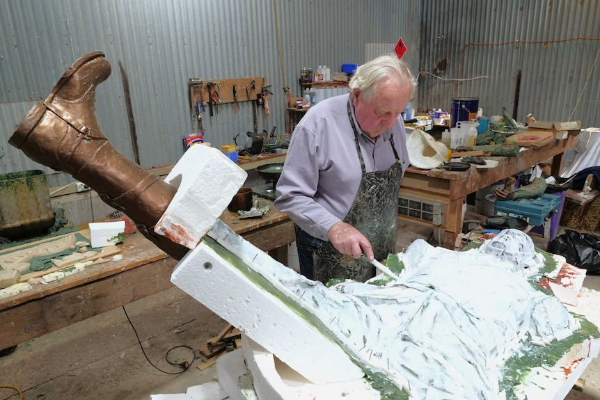 Sculptor Carl Valerius coats a statue of a WW1 soldier with a white paste
