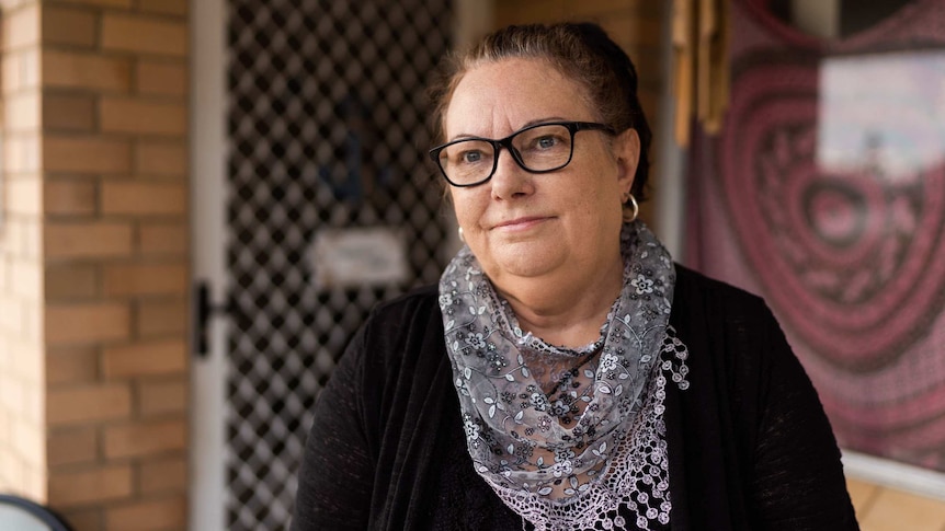 Close-up of a woman wearing glasses and a lacy scarf.