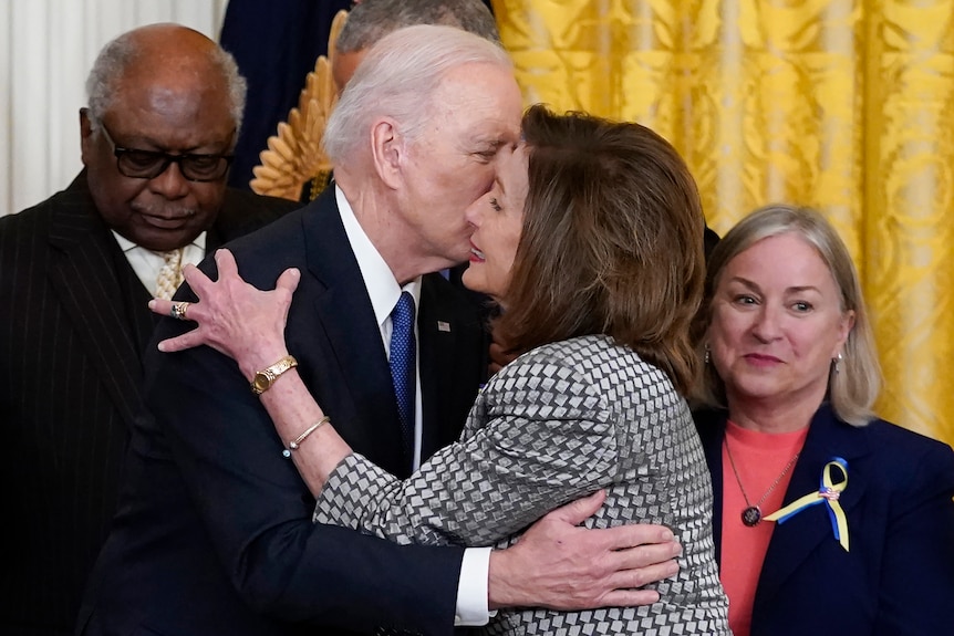 President Joe Biden greets House Speaker Nancy Pelosi with a cheek kiss.