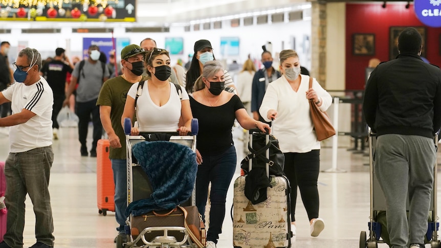 Travellers walk through Miami International Airport, Dec. 20, 2021, during the holiday break.