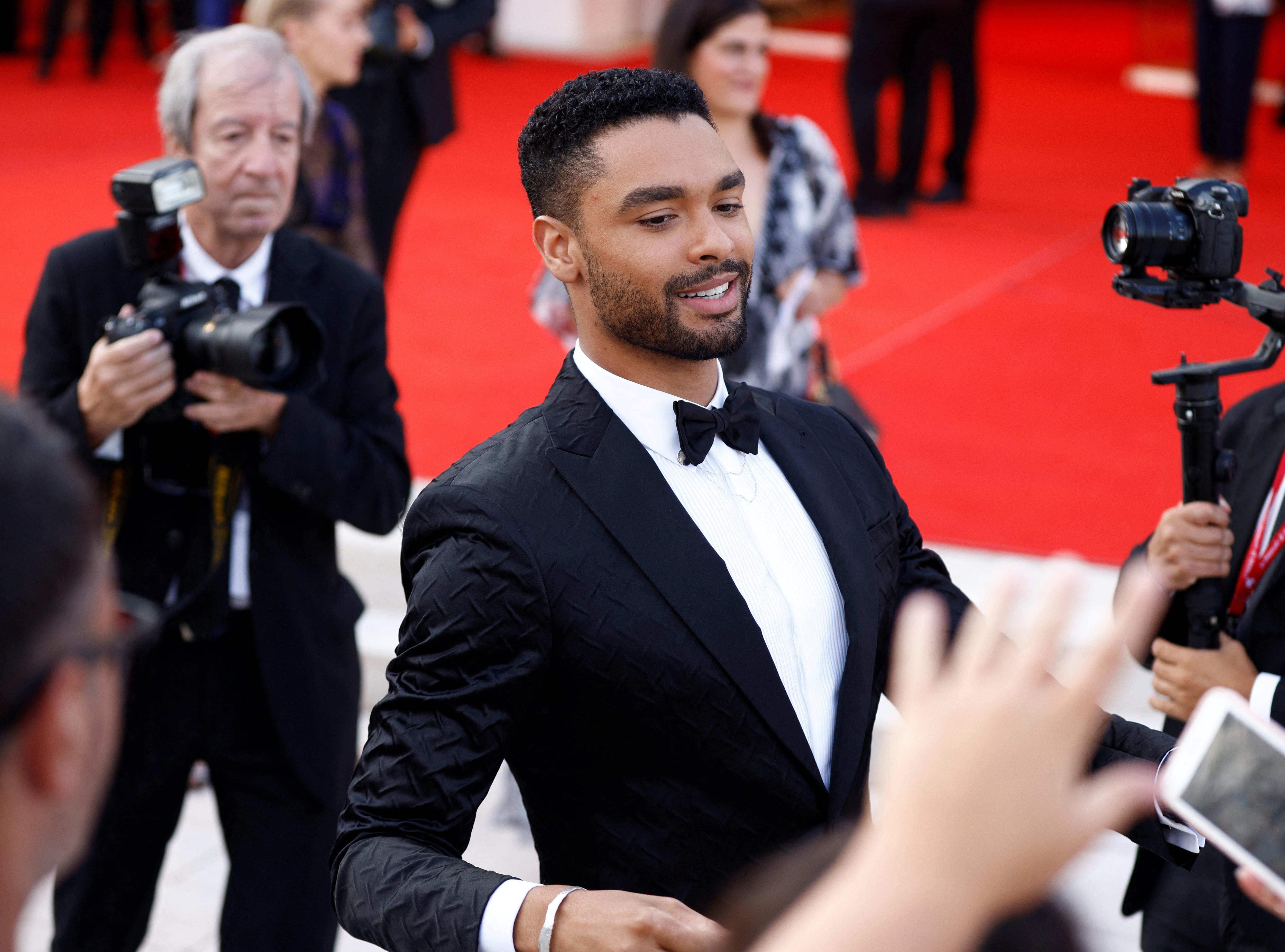 Regé interacts with fans on the red carpet.