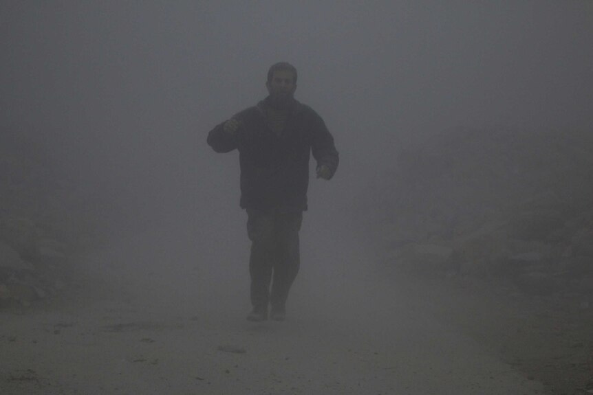 A man covered with dust walks at a site hit by an airstrike in Aleppo.