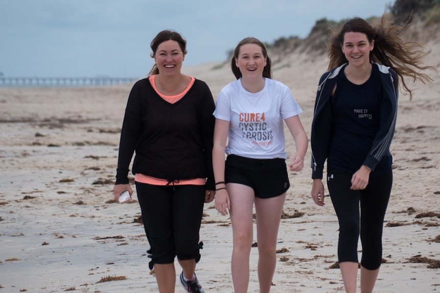 The Johnsons — Judy, Mae and Olivia — walk along an Adelaide beach.