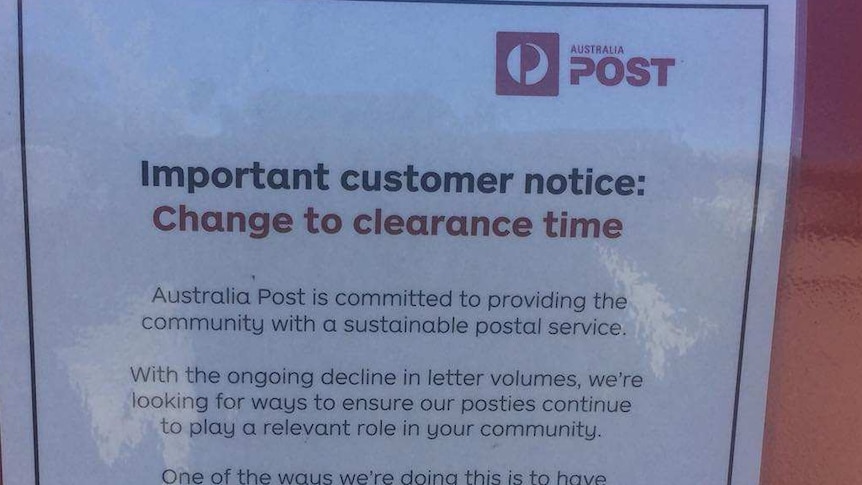 A notice on a post box announces a change to clearing times.