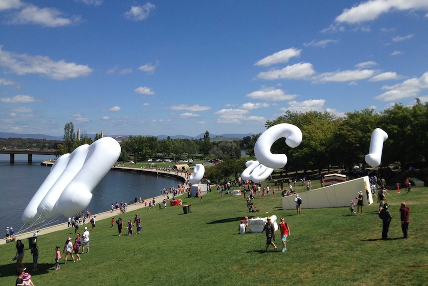 Giant letters collect next to Lake Burley Griffin to spell out words as part of Canberra's centenary celebrations.