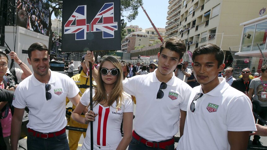 Cara Delevingne stands with grid boys at the Monaco F1 Grand Prix
