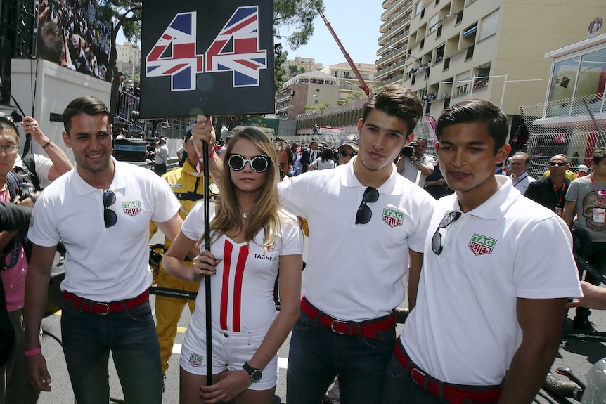 Cara Delevingne stands with grid boys at the Monaco F1 Grand Prix